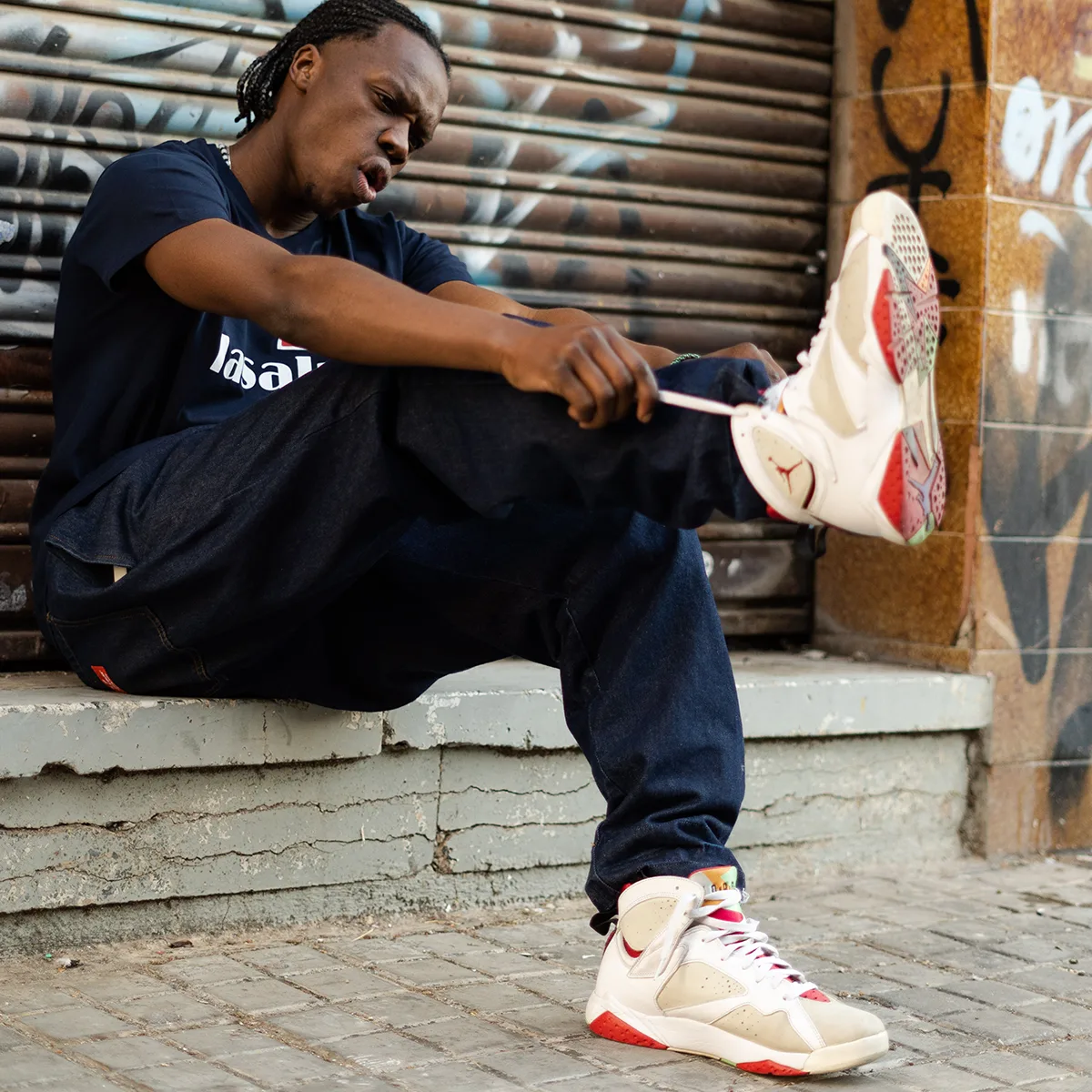 Modelo con camiseta La Salut Badaloners posando con zapatillas deportivas